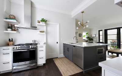 kitchen with white cupboards on the left and a grey peninsula, stainless steel oven and range hood with floating shelves | does a kitchen renovation increase my home's value