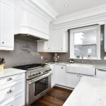A white cabinet kitchen with gray decorative backsplash
