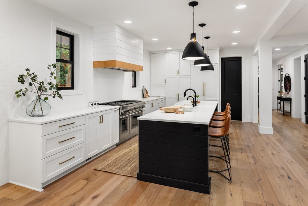 White kitchen with light coloured wood floor and accents