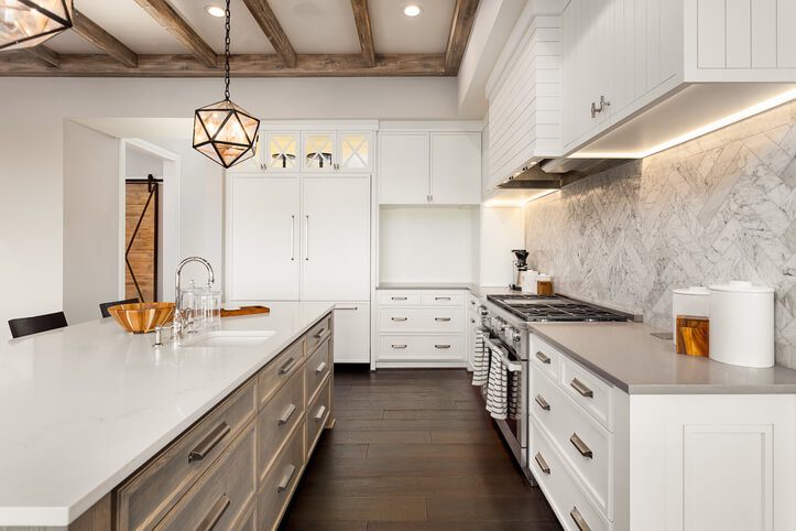 A large, modern kitchen with white cabinets and porcelain countertops.