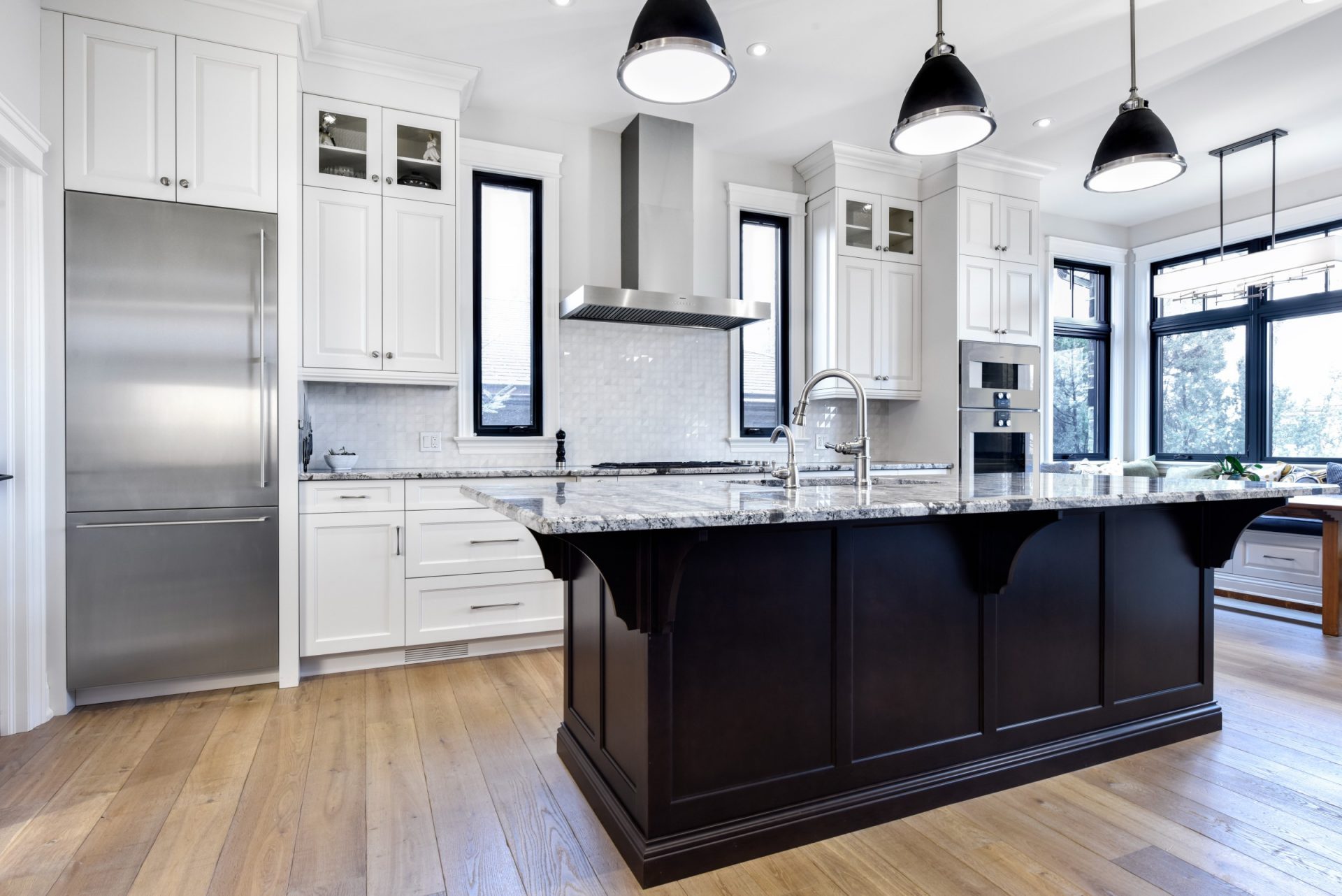 Elegant kitchen with white cabinetry, granite countertops, stainless steel appliances