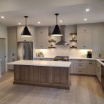 White kitchen with island and lights.
