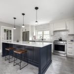 White kitchen with white backsplash and deep blue island.
