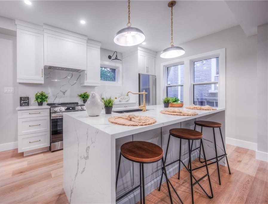 White kitchen with modern white countertops.
